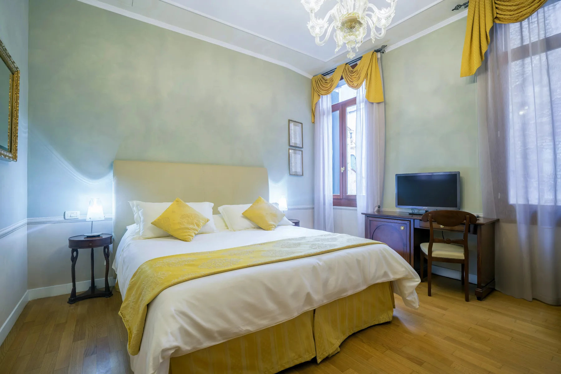 Classic room at Palazzo Vitturi with gold-detailed bed and Murano chandelier