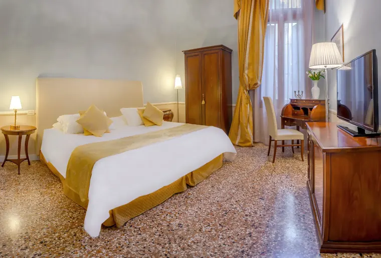 Camera Superior di Palazzo Vitturi con tendaggi dorati e scrittoio in legno
