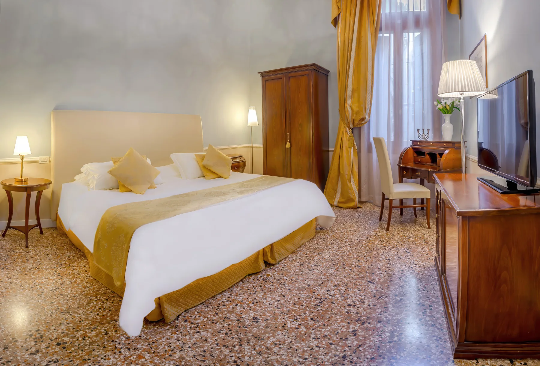 Superior room at Palazzo Vitturi with golden drapes and wooden writing desk